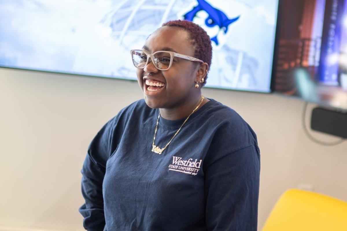 Psychology student smiling in Parenzo Hall wearing a navy blue WSU shirt.