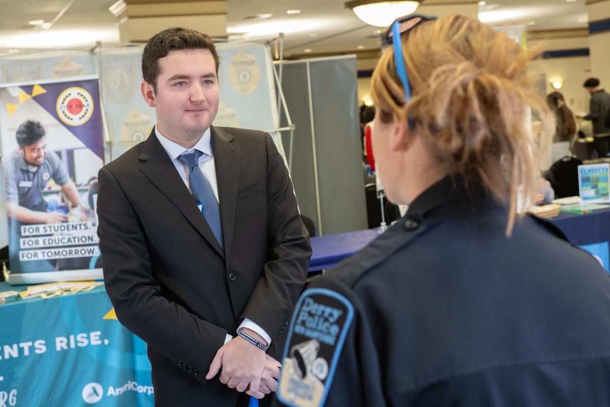 Criminal justice student chatting with a police officer at the Criminal Justice Career Fair.