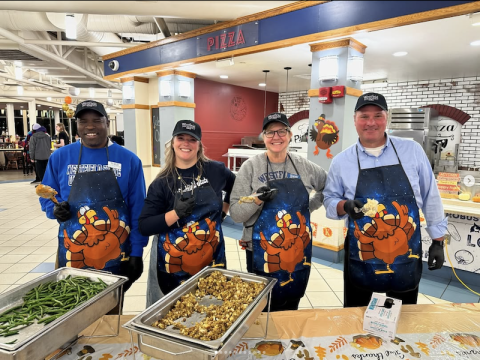 The 2024 Thanksgiving turkey dinner at the Dining Commons. Volunteers in turkey aprons service food to students, faculty, and staff.