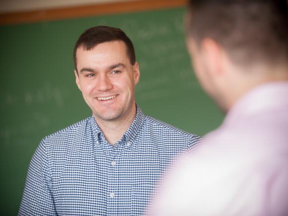 Male student smiling as he talks in the classroom