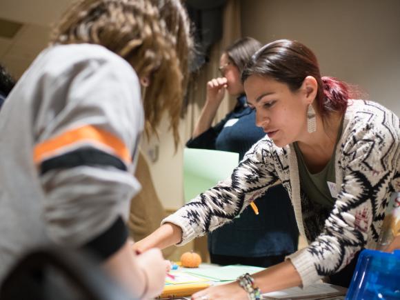 Teacher showing student material on a table