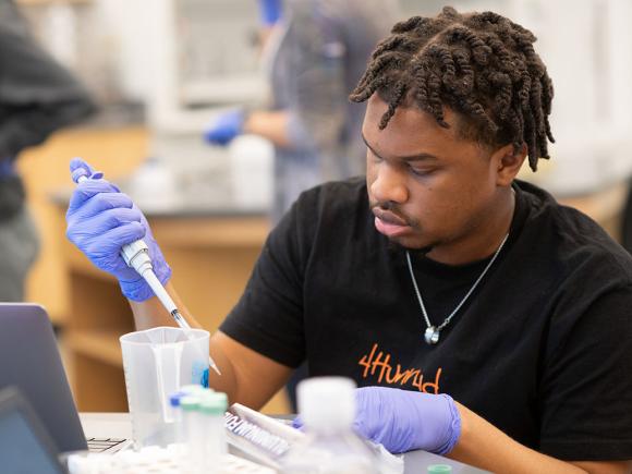 A biology major at Westfield State University conducts an experiment during class in a science lab.