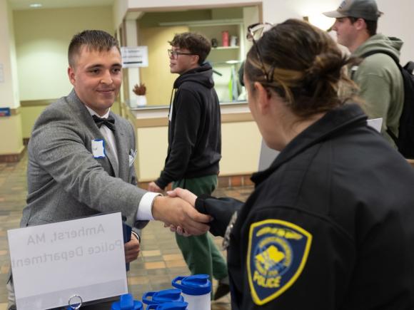 Student at Criminal Justice & Counseling Career Fair shaking hands with an employer.