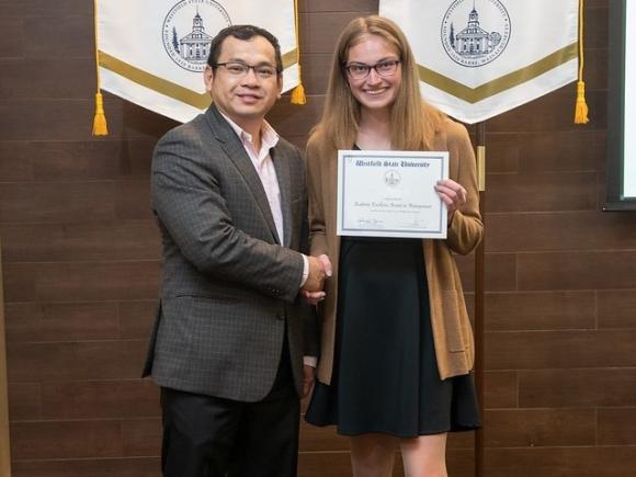 Finance student smiling with a faculty member at the Academic Excellence Award Ceremony. 