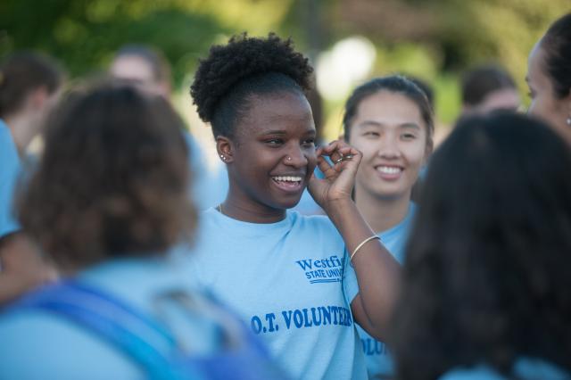 Image of smiling hoot day volunteer surrounded by peers