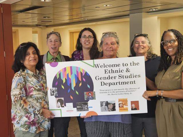 Ethnic and Gender Studies faculty holding a sign that says welcome to the department.