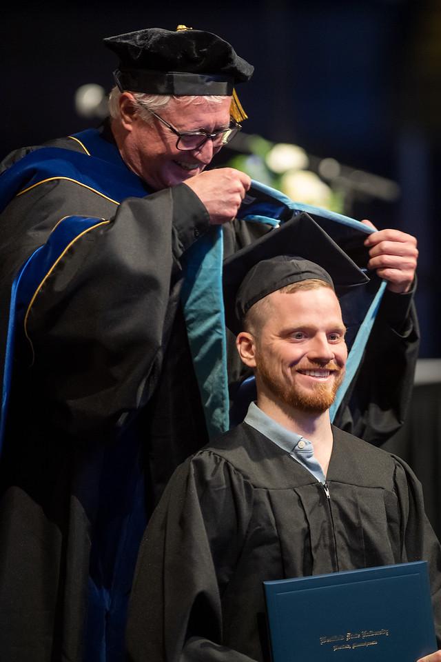 Graduate student at commencement with faculty member.