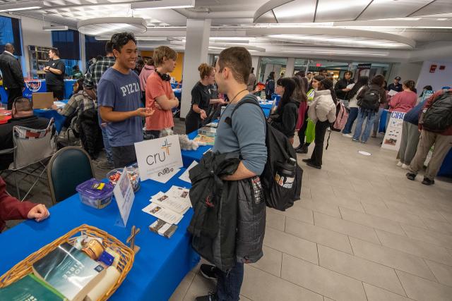 CRU table with two students chatting at the campus club fair.