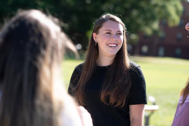 Education student smiling on the campus green.