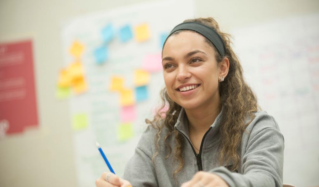 Student smiling with pen in hand.